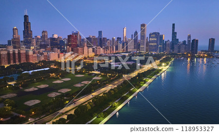 Aerial Chicago park at night with city lights and sunset glow over buildings with Lake Michigan, IL 118953327