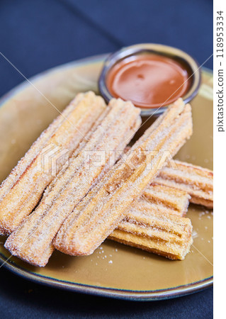 Crispy Sugar Coated Churros with Chocolate Sauce on Ceramic Plate Crispy Sugar Coated Churros with Chocolate Sauce on Ceramic Plate 118953334