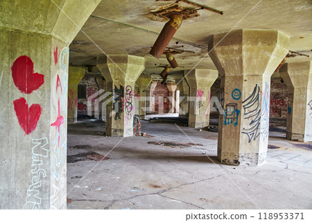 Graffiti-Adorned Abandoned Warehouse Interior with Rustic Decay 118953371