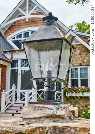 Elegant Outdoor Lantern on Stone Pillar with Modern Home Facade 118953384