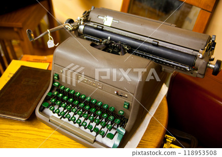 Vintage Typewriter with Green Keys on Wooden Desk in Warm Light 118953508
