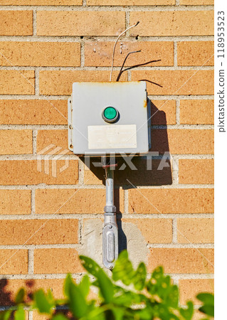 Aged Electrical Junction Box on Brick Wall with Green Foliage Aged Electrical Junction Box on Brick Wall with Green Foliage 118953523