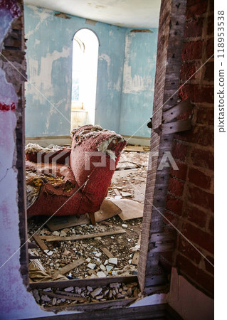 Abandoned Red Armchair in Decayed Room with Arched Window Forgotten Interior View 118953538
