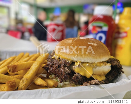 Juicy Double Smashburger with Fries in Casual Diner Setting, Close-Up View Juicy Double Smashburger with Fries in Casual Diner Setting, Close-Up View 118953541