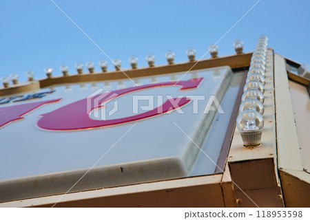 Vintage Sign Detail with Light Bulbs and Red Letter C Against Blue Sky 118953598