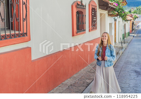Female tourist walks through the colonial streets San Cristobal de las Casas, Mexico. Cultural exploration, architecture, and travel experience concept Female tourist walks through the colonial streets San Cristobal de las Casas, Mexico. Cultural exploration, architecture, and travel experience concept 118954225