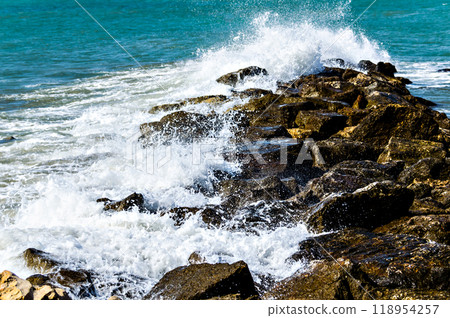 Close-up of sea waves breaking on the rocks of Vilanova y la Geltru beach	 118954257