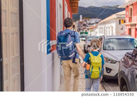 Father and and his two sons, a teenager and a baby tourists walks through the colonial streets San Cristobal de las Casas, Mexico. Cultural exploration, architecture, and travel experience concept 118954330