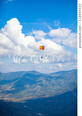People paragliding over the beautiful mountains of the Antioquia department in Colombia. Tandem Paragliding. Extreme sport concept. 118954333