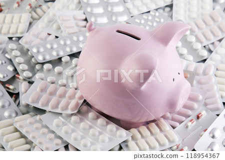 Pink piggy bank on big heap of many various pills and tablets packs for savings and healthcare concept 118954367