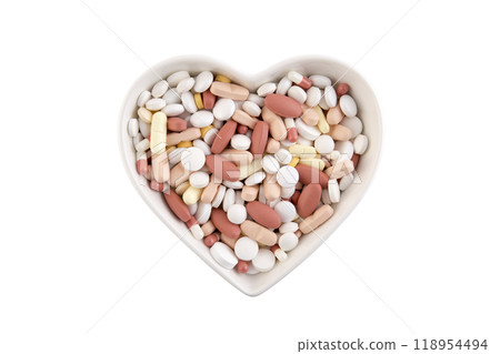 Plate in shape of heart with heap of medicine pills or dietary supplements isolated on white background 118954494