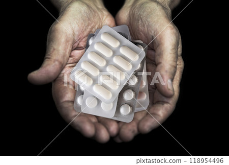 Heap of medicine pills in senior hands over black background Heap of medicine pills in senior hands over black background 118954496