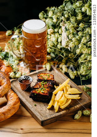 Beer with roasted ribs and French fries, perfect meal for a traditional pub or restaurant setting Beer with roasted ribs and French fries, perfect meal for a traditional pub or restaurant setting 118954613