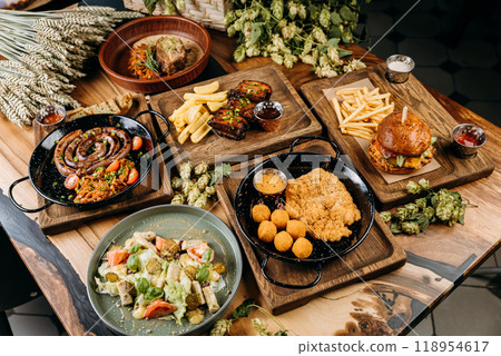Top view of gourmet food dishes including sausages, ribs, schnitzel, salad, and burger on table Top view of gourmet food dishes including sausages, ribs, schnitzel, salad, and burger on table 118954617