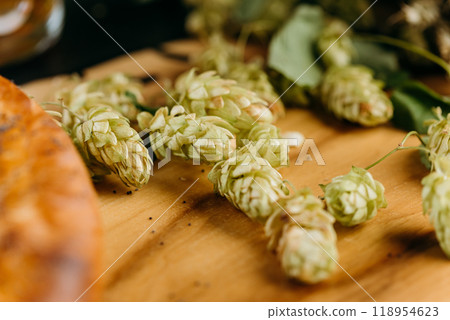 Fresh hops on a wooden table, symbolizing natural brewing ingredients used in craft beer production 118954623