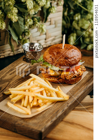 Delicious pulled pork burger with fresh lettuce and melted cheese served with French fries on board 118954631