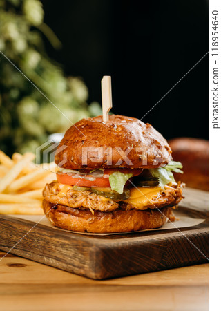 Delicious pulled pork burger with fresh lettuce and melted cheese served with French fries on board Delicious pulled pork burger with fresh lettuce and melted cheese served with French fries on board 118954640