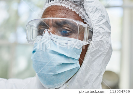 Close up of African American male production worker wearing protective glasses and mask while working with chemicals at pharmaceutical manufacturing plant Close up of African American male production worker wearing protective glasses and mask while working with chemicals at pharmaceutical manufacturing plant 118954769