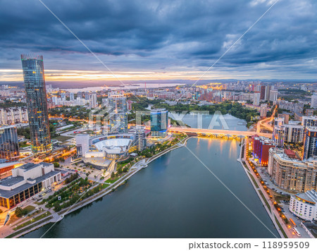 Yekaterinburg city and pond aerial panoramic view at summer or early autumn sunset. Night city in the early autumn or summer. Yekaterinburg city and pond aerial panoramic view at summer or early autumn sunset. Night city in the early autumn or summer. 118959509