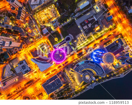 A top down, aerial view of Yekaterinburg city at night. A few vehicles are in view, surrounded by stores, restaurants, bars and warehouses. A top down, aerial view of Yekaterinburg city at night. A few vehicles are in view, surrounded by stores, restaurants, bars and warehouses. 118959513