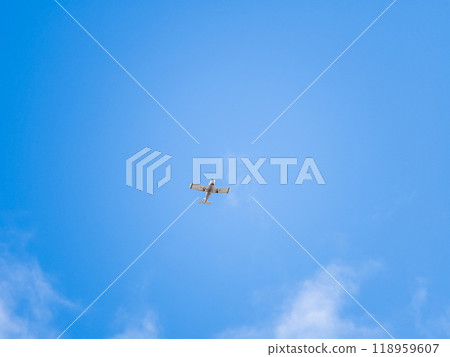 Small ultralight airplane with overhead wing and single propeller flying in sunset sky. Small ultralight airplane with overhead wing and single propeller flying in sunset sky. 118959607