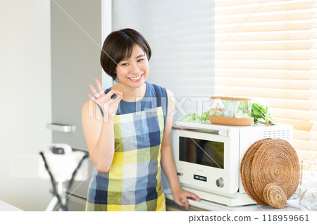 A woman recording a cooking video in front of a microwave A woman recording a cooking video in front of a microwave 118959661