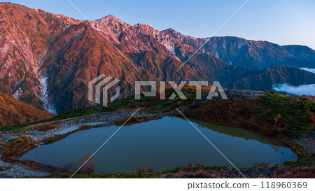 Autumn climbing on Mt. Karamatsu: Happoike Pond and the Hakuba Sanzan mountains at dawn Autumn climbing on Mt. Karamatsu: Happoike Pond and the Hakuba Sanzan mountains at dawn 118960369