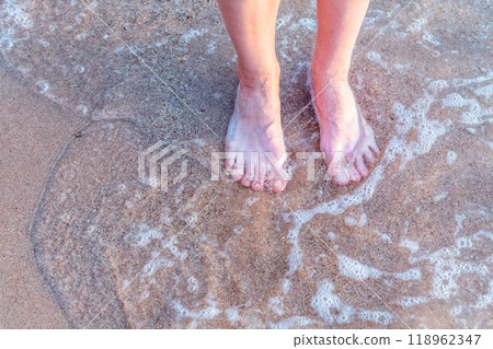 Beach - women's foot and the grains of sand. Beach - women's foot and the grains of sand. 118962347