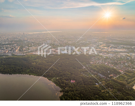 Big lake with green shores in bright sun light and city on horizon, aerial landscape. Recreation concept. Aerial view 118962366
