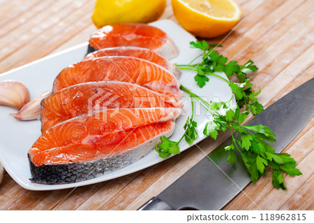 Raw salmon steaks with lemon, parsley, garlic Raw salmon steaks with lemon, parsley, garlic 118962815