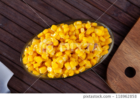 Grains boiled corn on plate on wooden table. Vegetarian ingredient 118962858
