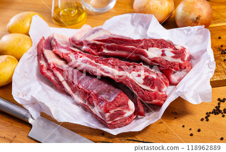 Raw beef ribs on board, potato tubers and whole onions 118962889
