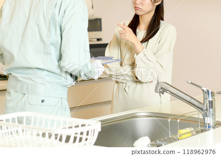 一名婦女向廚房裡的一名男工抱怨 一名婦女向廚房裡的一名男工抱怨 118962976