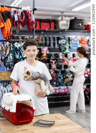 Teen boy choose carrier for small pet Yorkshire terrier dog Teen boy choose carrier for small pet Yorkshire terrier dog 118962999