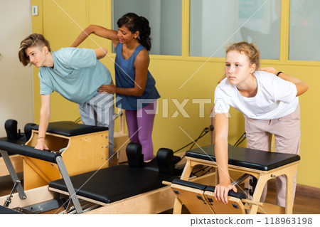 Teenagers training pilates in gym with trainer 118963198