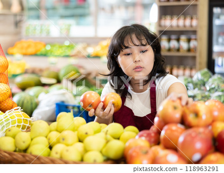 Young asian salesgirl arranging apples on produce display Young asian salesgirl arranging apples on produce display 118963291