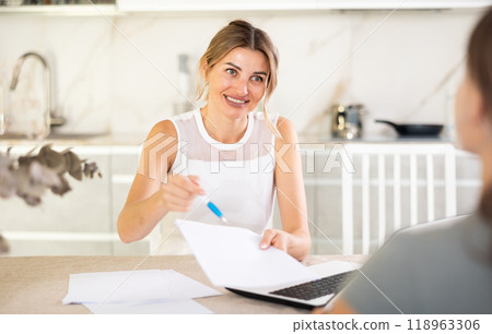 Middle-aged woman communicating with partner in the kitchen 118963306