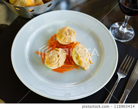 Several boiled chicken eggs with meat filling are laid out on plate. 118963414