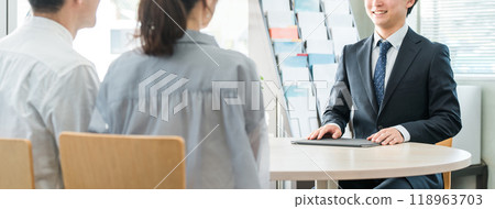 A young Asian businessman and his customer couple serving in a showroom/business negotiation space A young Asian businessman and his customer couple serving in a showroom/business negotiation space 118963703