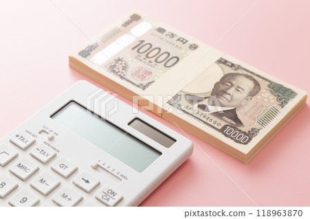 A stack of 10,000 yen bills and a calculator on a pink background 118963870