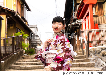 A woman in a kimono walking around town 118963984