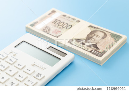 一疊 10,000 日元鈔票和藍色背景上的計算器 118964031