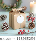 Christmas gift tag mockup. Top view round blank white circle sticker for brand logo label design with brown cardboard kraft paper box on blue wooden table background. AI generated 118965254