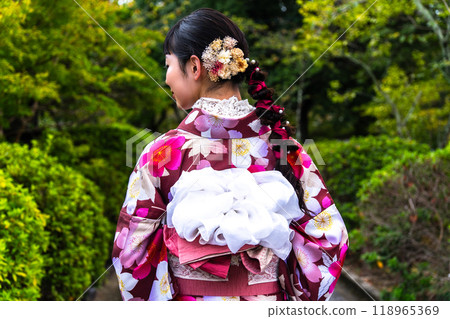 A woman in a kimono walking around town A woman in a kimono walking around town 118965369