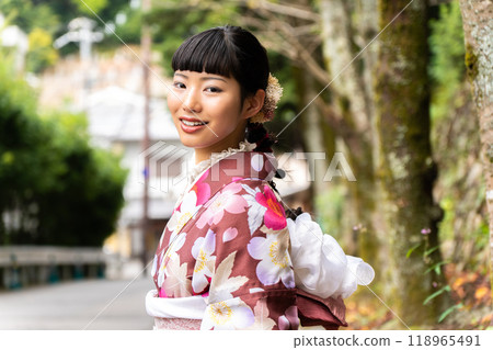 A woman in a kimono walking around town 118965491