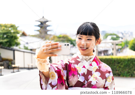 A woman in a kimono taking a selfie 118966078