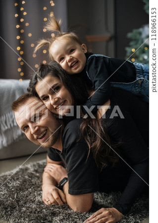 Happy family playing together near Christmas tree at home Happy family playing together near Christmas tree at home 118966153