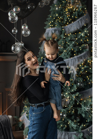 Joyful moment with mother and child by Christmas tree 118966267