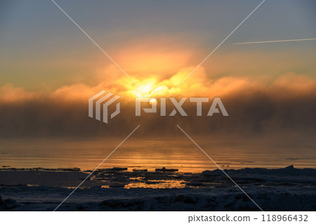 Beautiful sunset with fog in Arctic sea at winter time. Fog at sea. Frozen air. Beautiful sunset with fog in Arctic sea at winter time. Fog at sea. Frozen air. 118966432