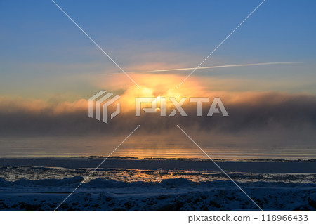 Beautiful sunset with fog in Arctic sea at winter time. Fog at sea. Frozen air. 118966433